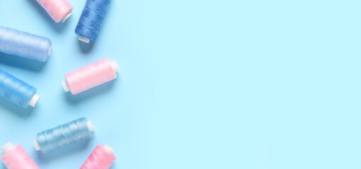 Many thread spools on blue background with space for text, top view