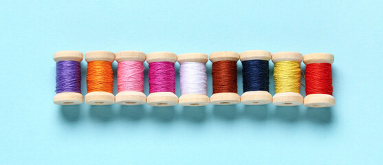 Spools of colorful thread on blue background