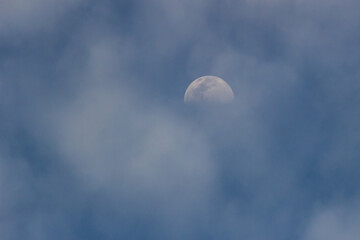 moon in blue sky with clouds