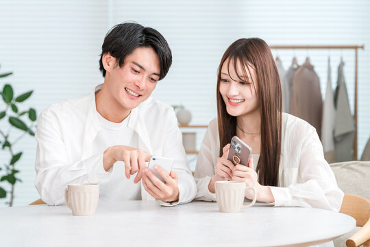 Couple having a conversation while drinking hot drinks at the dining table - Powered by Adobe