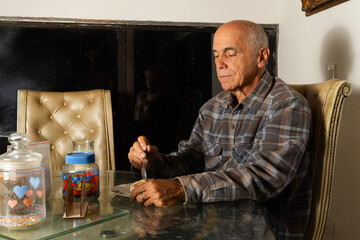 Elderly person eating at glass dining table with jars and tufted chair