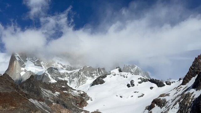 Time-lapse of clouds swirling around Mount Fitz Roy, Laguna de los Tres. Zoom out effect. Concept of passage of time, the greatness of nature, broadening perspective and eternal winter beauty