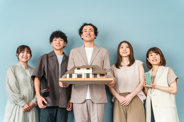 Male and female staff of a house manufacturer, design office, or construction company holding an architectural model or house model