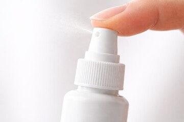 Macro finger pressing unbranded nasal spray pump allergy relief concept clean copy space