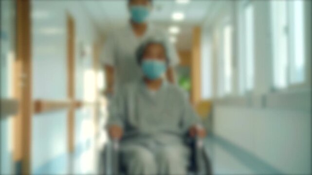 ぼかし背景素材: 福祉施設／病院の廊下を高齢者の座る車椅子を押して歩く介護士／看護師　