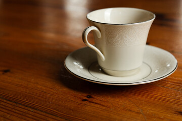 Fine Porcelain Teacup and Saucer on Worn Wooden Surface
