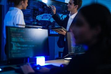 Automotive engineer presenting electric car design on large digital screen. Technical team analyzing vehicle aerodynamics and engine performance data in high-tech laboratory.