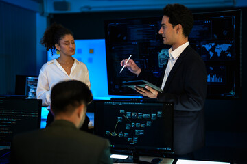 Automotive engineer presenting electric car design on large digital screen. Technical team analyzing vehicle aerodynamics and engine performance data in high-tech laboratory.