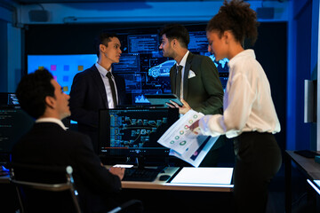 Automotive engineer presenting electric car design on large digital screen. Technical team analyzing vehicle aerodynamics and engine performance data in high-tech laboratory.