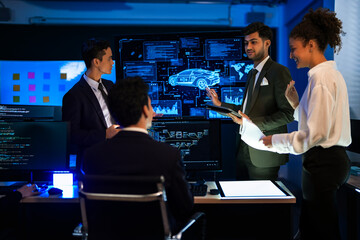 Autonomous driving software developers discussing car AI navigation system. IT specialist explaining self-driving vehicle simulation data to colleagues in modern control room.