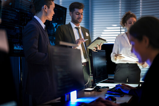 Autonomous driving software team reviewing car AI simulation. Engineers and managers discussing self-driving vehicle safety systems in high-tech control room center. - Powered by Adobe