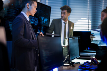 Industrial design team planning smart mobility transport. Professionals analyzing futuristic car prototype and engineering schematics on digital screens at night.