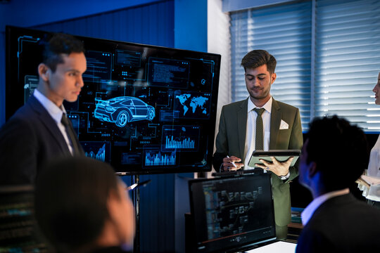 Automotive executives discussing electric car market strategy. Business leadership team analyzing vehicle sales data and future design trends in modern night office. - Powered by Adobe
