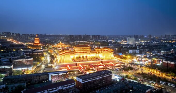 Aerial time-lapse of Yingtian Gate in Luoyang at night, illuminated landmark architecture and vibrant city life under the twilight sky, Henan Province, China