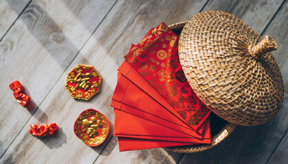 Group of Angpao in a Basket. Chinese New Year. A flat-lay shot of a small, decorative woven basket overflowing with various red envelopes received by the family, showing the collection of good wishes.