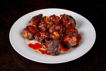 A plate of Caribbean browned oxtail on a dark table