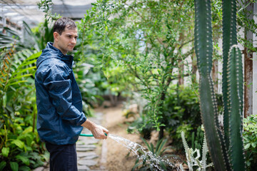 Young scientist in farm is part of agricultural research team working carefully to water plants and support growth in natural environment with dedication and focus