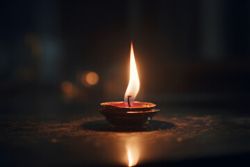 Candle glowing softly in a dark room creates a warm and calming atmosphere for relaxation