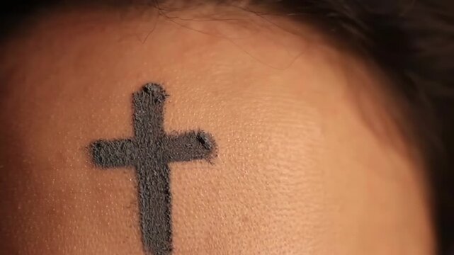 Close up video of a woman forehead with an ash cross on ash wednesday, a christian holy day of prayer, fasting, and repentance.