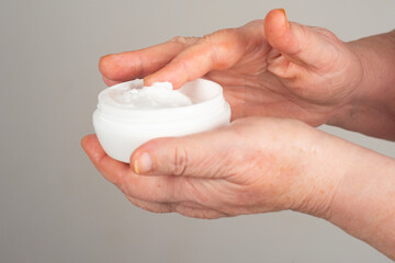 Wrinkles on aging hands with skincare cream. Wrinkles on mature hand with cream. Wrinkles treated with moisturizing hand cream. Cream on aged hands.