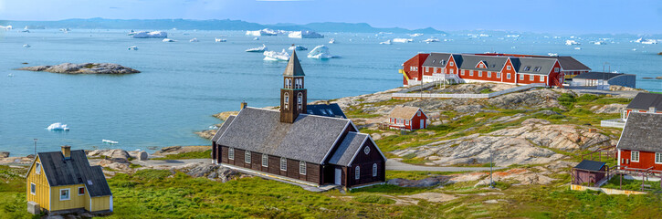 Typical architecture of Greenland Ilulissat with colored houses located near fjords and icebergs.