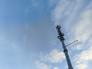 Communication Tower Against a Cloudy Blue Sky