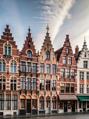 Fototapeta premium Colorful medieval houses with stepped gables and ornate chimneys stand out against the vibrant backdrop of Bruges Markt Market Square