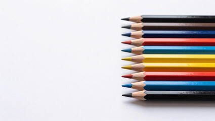 Fototapeta premium A neat row of sharpened colored pencils displaying a vibrant spectrum of colors is arranged against a clean white background, creating a minimalist and artistic composition.