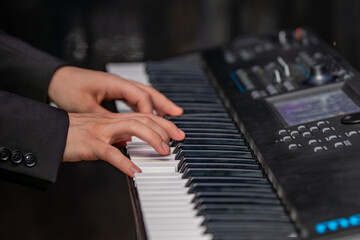 hands of a man playing the piano