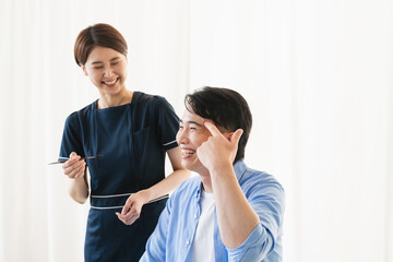 メイクアップアーティストに眉毛をメイクしてもらってる若い男性　ビューティイメージ