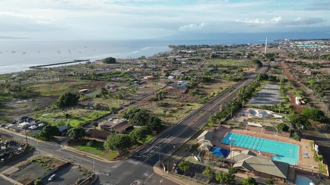 lahaina hawaii aerial view (small down devastated by fire cleaning and rebuilding) cars driving on road clear sunny day tropical pacific island travel tourism destination (burn disaster aftermath)