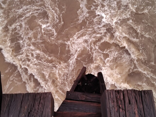 Top view of turbulent stream.  Los Angeles river after rain. Swirl of foam on water surface.