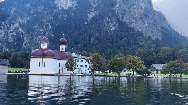 St Bartholomew Church on the shore of Lake K&ouml;nigssee in Berchtesgaden, Germany. Calm alpine water reflects historic church architecture and steep forested mountains.