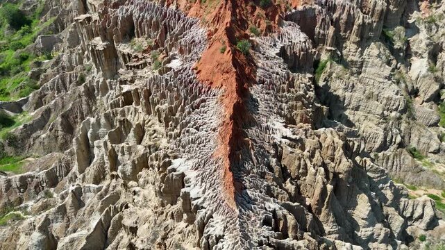 Cinematic drone close-up intricate red clay textures and sharp eroded ridges at Miradouro da Lua (Viewpoint of the Moon) in Belas Municipality, Luanda Province, Angola, Africa