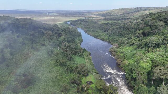 Wide aerial drone perspective of the Lucala River flowing through the lush tropical landscape of Calandula Municipality, Malanje Province, Angola, Africa