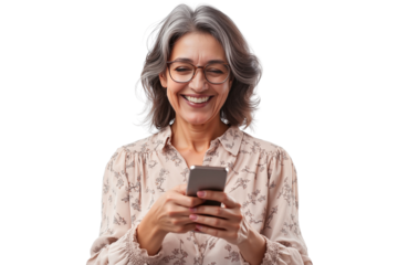 Joyful mature woman with grey hair and glasses, smiling while holding and using a smartphone isolated on white background