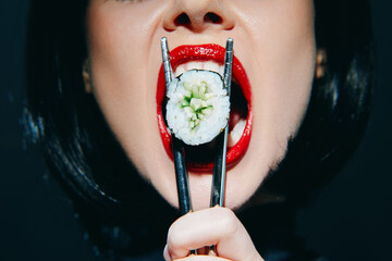 Bold sushi indulgence: a close-up of a woman with red lips holding sushi with chopsticks, showcasing vibrant colors and excitement in a modern setting.