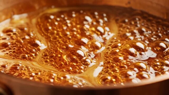 Close-up of rich golden-brown liquid vigorously boiling and bubbling in a copper pot, showcasing the mesmerizing process of culinary transformation for syrups, caramels, or sweet reductions