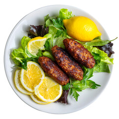 Grilled meat patties on fresh lettuce with lemon, parsley, cucumber, tomato, and olive garnish, Mediterranean cuisine on white plate, top view