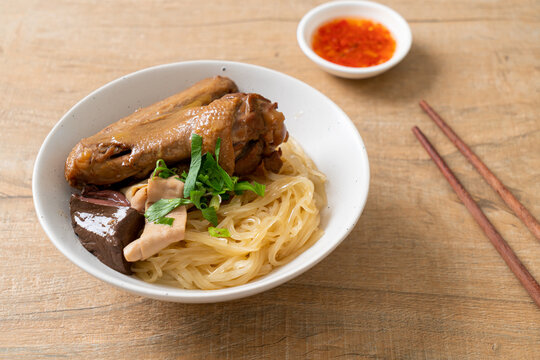 dried noodles with braised duck in white bowl