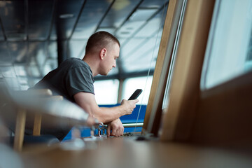 Young Man Scrolling Through Phone News Social Media Feed, Seamen Fatigue And Social Isolation, Mental Health Issues And Loneliness At Sea