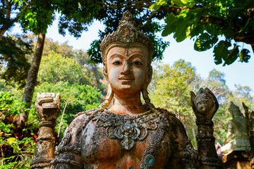 Intricate four-armed deity statue at the Wat Pha Lat forest temple in Chiang Mai, Northern Thailand