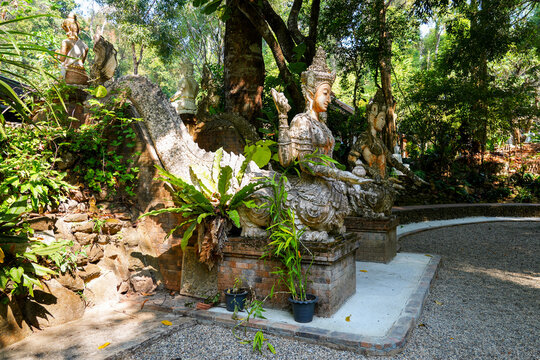 Intricate four-armed deity statue at the Wat Pha Lat forest temple in Chiang Mai, Northern Thailand