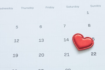 Red heart on calendar page marking February 14th for Valentine's Day. Romantic concept for love, dating, anniversary, and wedding planning. Minimalist design for holiday marketing and greeting cards.