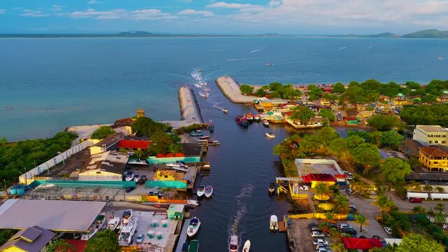 each in Paran&aacute;, Brazil, with small fishing and leisure boats floating on the greenish Atlantic sea. Drone view of the sandy shoreline, calm coastal waters, and boats anchored near the beach on a sunny