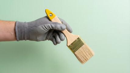 Hand in glove holding new paint brush