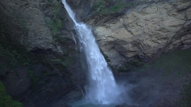 Reichenbachfall near Meiringen, Switzerland, filmed along the Via Alpina hiking route. Powerful alpine waterfall plunging down steep rock walls in a dramatic mountain landscape.