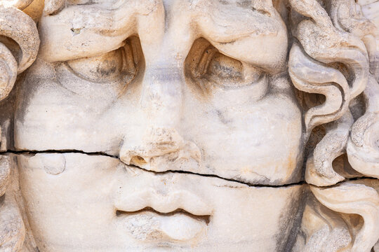 Ancient stone Medusa sculpture with cracked surface and detailed curly hair, mythical Medusa Gorgon - Powered by Adobe
