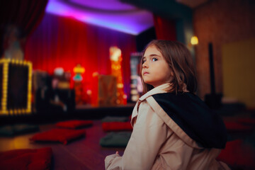 Little Girl Waiting for the Magic Show to Start.  spectator in the audience enjoying entertainment performance about to begin 

