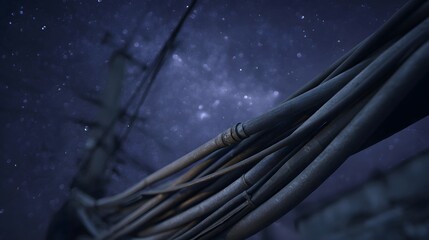 Thick weathered power cables stretch across a deep blue starry night sky creating a sense of industrial mystery